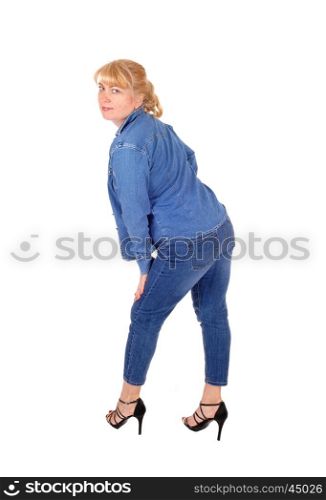 A pretty woman in jeans pants and jacket standing in profile, lookingover her shoulder, isolated for white background.