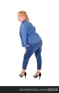 A pretty woman in jeans pants and jacket standing in profile, lookingover her shoulder, isolated for white background.