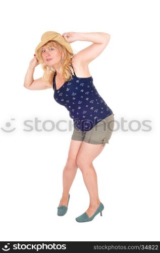 A pretty woman in shorts, holding a straw hat on her head,isolated for white background.