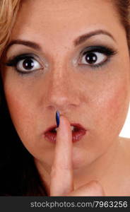 A pretty woman&rsquo;s face in a closeup picture holding one finger over hermouth, quiet, isolated for white background.