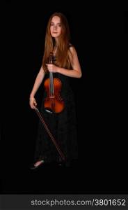 A pretty woman standing for black background holding her violin.