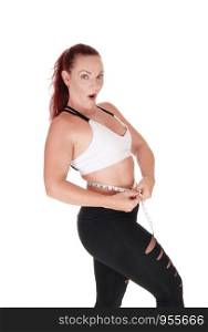 A pretty woman standing in workout outfits measuring her stomach and is very surprised what she sees, isolated for white background