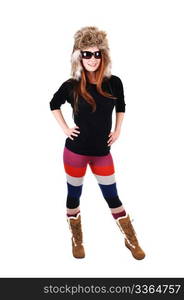 A pretty woman with long red hair in colorful tights, a black sweater and a fur hat and brown boots smiling for a portrait for white background.