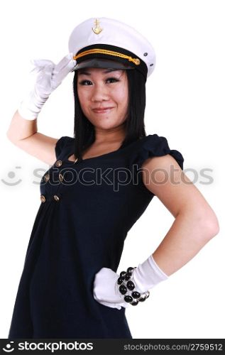 A pretty young Asian woman, in a sailor uniform, in white gloves, and a sailor cap, standing saluting in the studio.