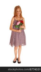 A pretty young girl in a burgundy dress holding her two roses, smiling,isolated for white background.