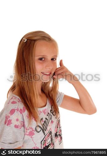 A pretty young girl with blond hair standing in profile for white background pretending to make a phone call.
