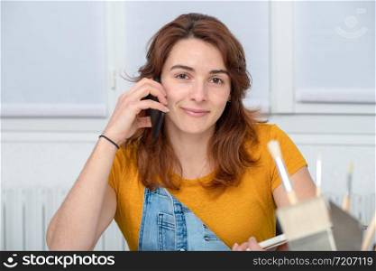 a pretty young woman doing DIY talking on phone