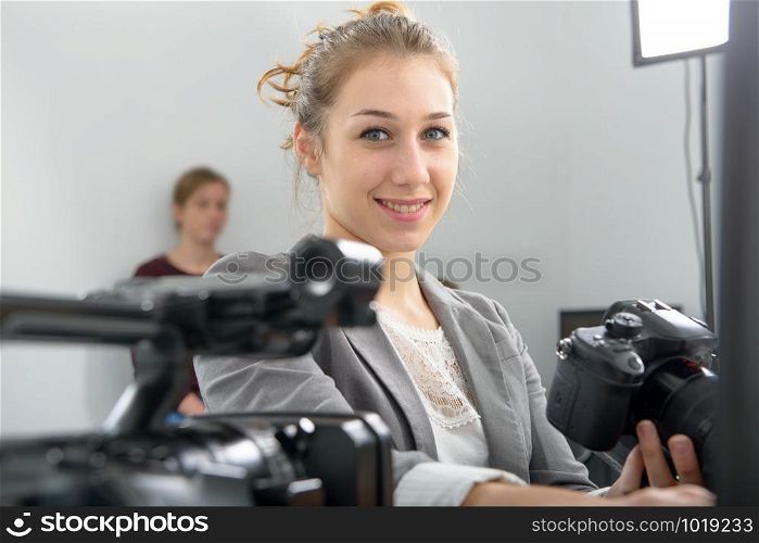 a pretty young woman photographer with camera in office