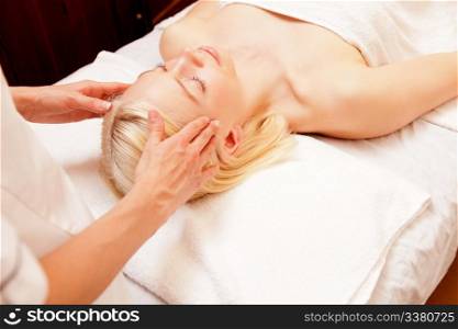 A pretty young woman receiving a scalp massage in a spa
