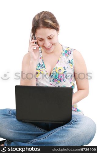 A pretty young woman sitting on floor with laptop and mobile phone