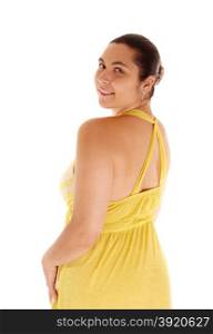 A pretty young woman standing in a yellow dress and looking over hershoulder, isolated for white background.