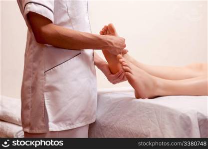 A professional masseur giving a foot massage in a spa