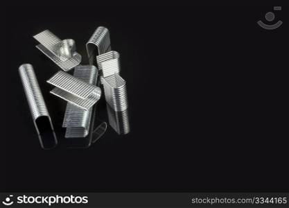 a professional pile of staples on a black background