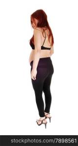 A profile few of a pregnant woman in a black bra and tightsand red hair, isolated for white background.