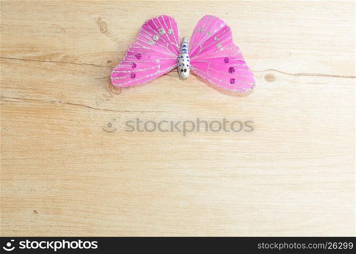 A purple silk butterfly used for decoration isolated on a wooden background