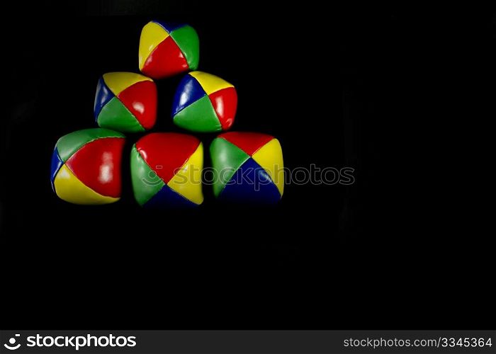 a Pyramid juggling balls on a black background