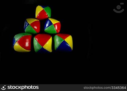 a Pyramid juggling balls on a black background