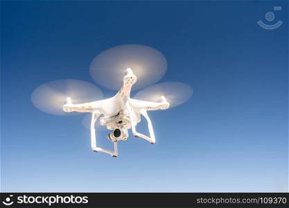 A Quadcopter hovering against a dark blue sky in a long panoramic composition