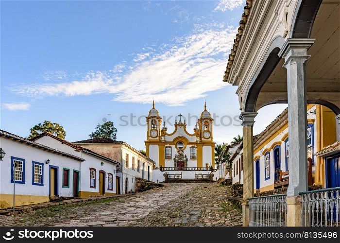 A quiet historic street in the city of Tiradentes in Minas Gerais with colonial houses and a baroque church in the background. A quiet historic street in the city of Tiradentes in Minas Gerais