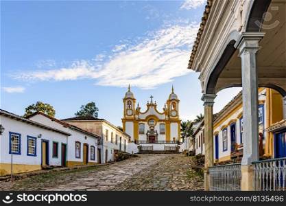 A quiet historic street in the city of Tiradentes in Minas Gerais with colonial houses and a baroque church in the background. A quiet historic street in the city of Tiradentes in Minas Gerais