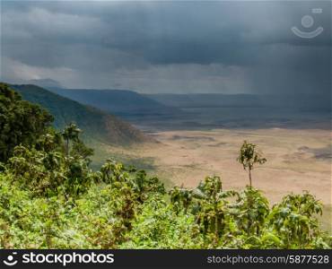 A rain storm passes over the Ngorongoro Crater as it is viewed from the rim of the Crater.