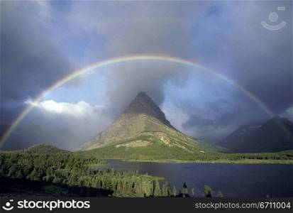 A rainbow hangs over Grinnel Point in Glacier National Park, in Montana, USA
