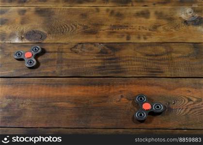 A rare handmade wooden fidget spinners lies on a brown wooden background surface. Trendy stress relieving toys