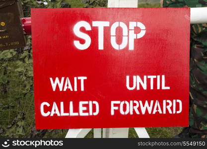 A red and white military checkpoint stop sign in a war zone