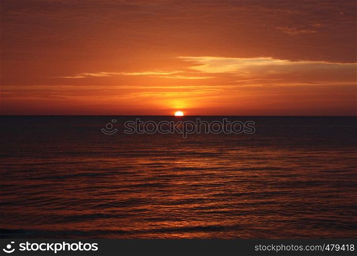 A red and yellow sunset over the ocean in Thailand