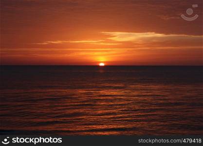 A red and yellow sunset over the ocean in Thailand