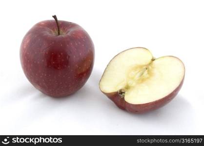 A red apple next to half an apple