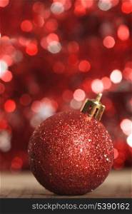 A red christmas bauble on the background of red boken