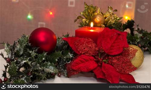 A red christmas candle amongst christmas decorations