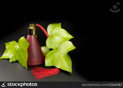 a red perfume bottle with rose leaves