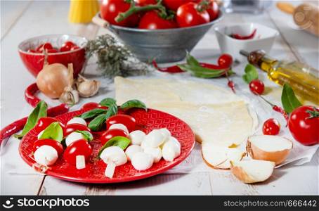 a red plate with small tomatoes and mozzarella