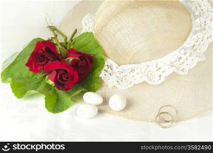 a red roses and wedding rings on white background
