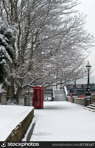 A red telephone box beside a walkway, on a cold Winter&rsquo;s day, London, England.