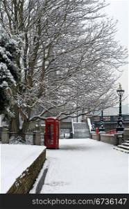 A red telephone box beside a walkway, on a cold Winter&rsquo;s day, London, England.