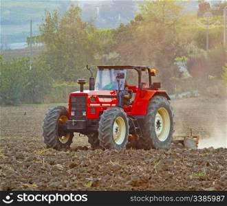 A red tractor working on a field