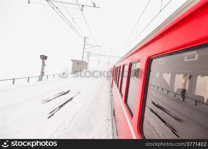 A red train in the middle of a desert of snow