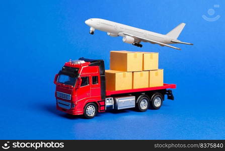 A red truck with boxes and cargo plane. Goods transportation services company. Logistics and infrastructure. Warehousing and supply. Optimization of delivery. Import and export of products