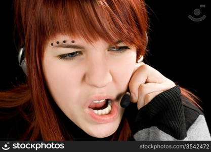 A redhead girl swearing on the microphone talking to a customer or being unpolite and stressed. Studio shot.