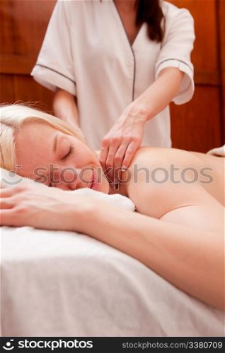 A relaxed peaceful woman receiving a shoulder massage at a spa