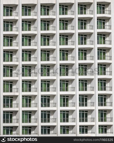 a repeating pattern of windows and a balcony. Windows of a hotel building.