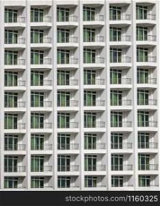 a repeating pattern of windows and a balcony. Windows of a hotel building.