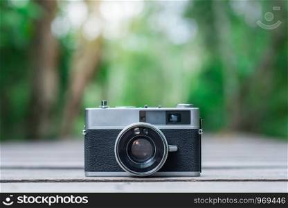 a retro camera on wooden plate in the forest