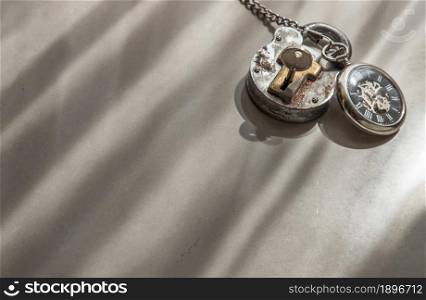 A retro pocket watch and Old vintage iron padlock that have light through on white background. Concept of light, hope and Value of time. Copy space, Selective focus.