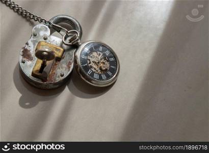 A retro pocket watch and Old vintage iron padlock that have light through on white background. Concept of light, hope and Value of time. Copy space, Selective focus.