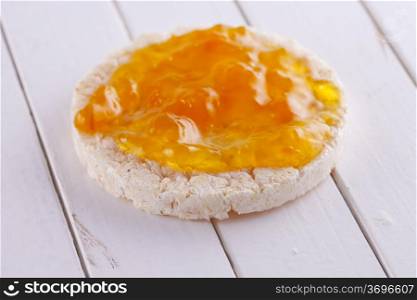 A rice toast with apricot jam over white wood