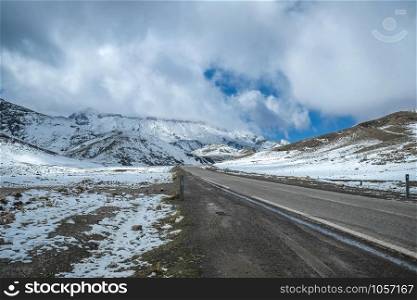 A road surrounded by snow capped mountains in the High Atlas range. Morocco.